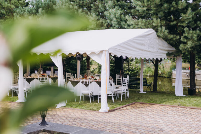 A summer tent with tables, food and chairs on the wedding day